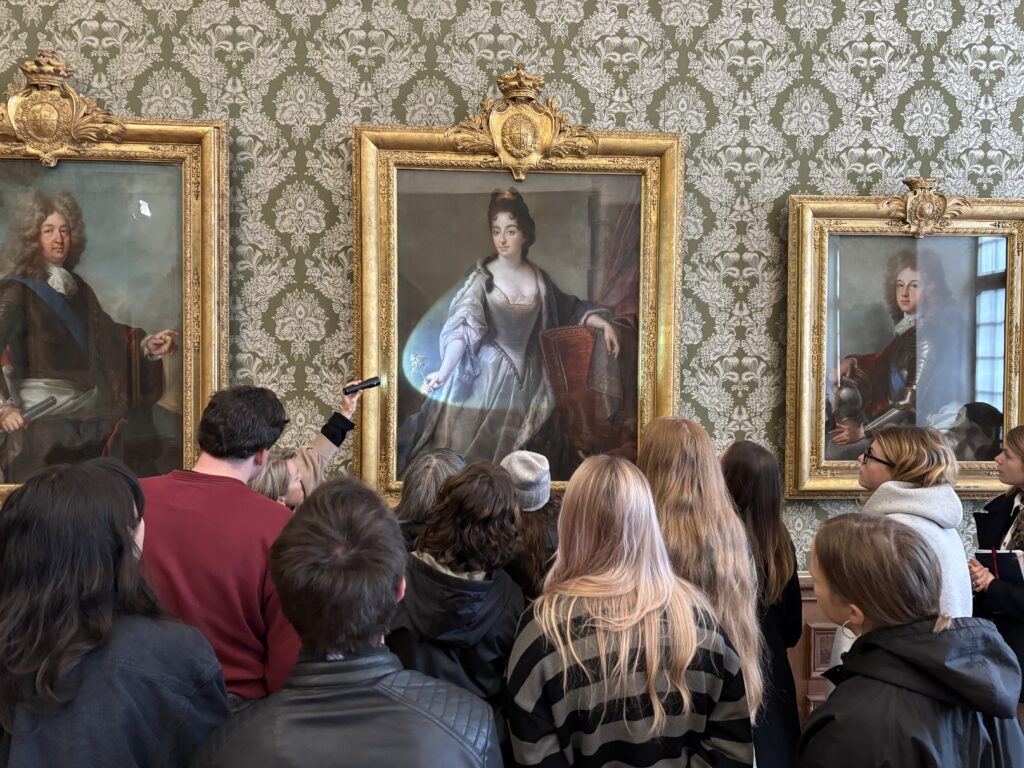 Eine Gruppe von Studierenden vor Gemälden in der Staatsgalerie Schleißheim.